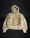 Chaqueta Saint Krew de piel sintética beige con capucha, cierre frontal y logo Nike negro en el bajo acanalado.