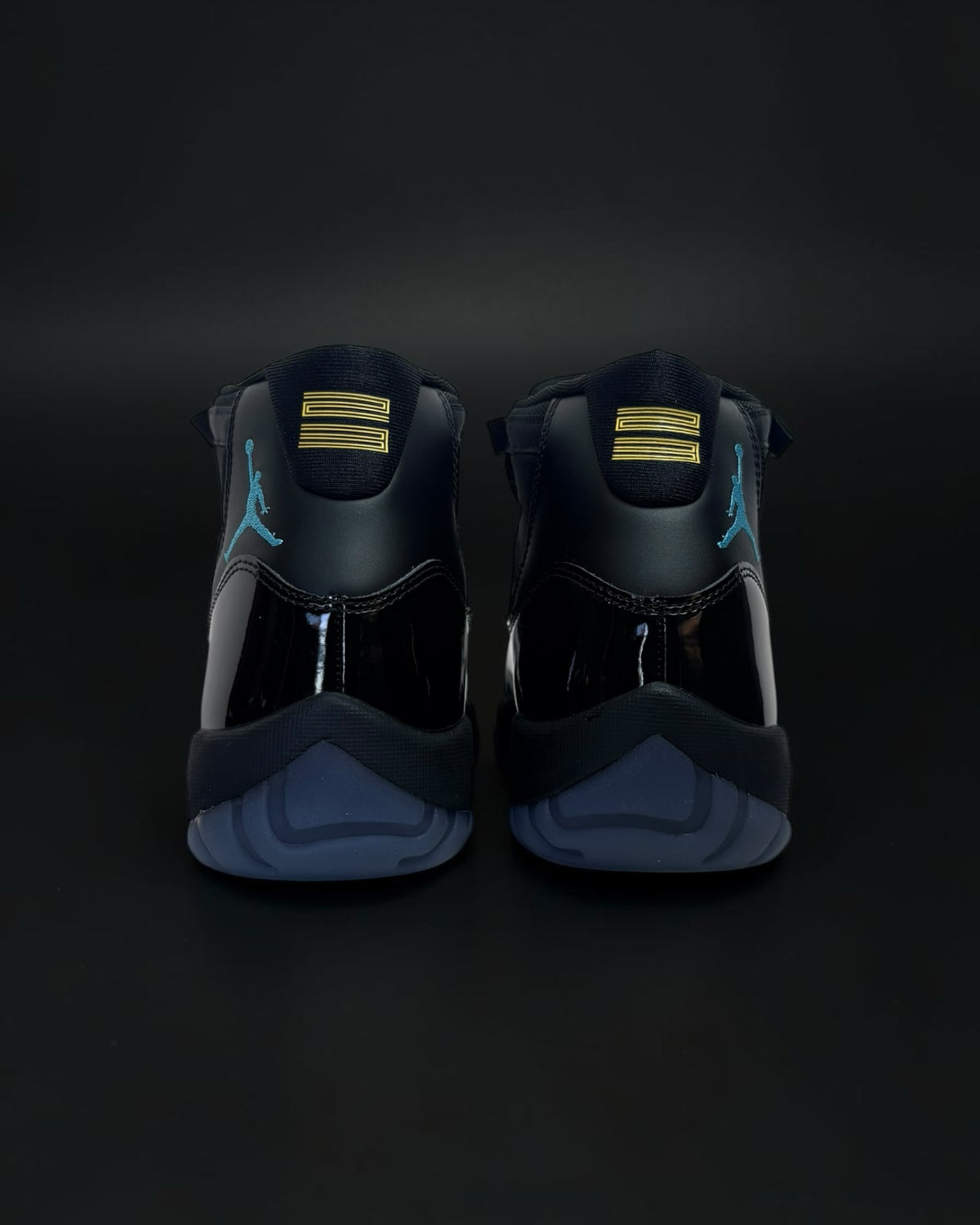 Vista trasera de zapatillas Saint Krew Jordan Retro negras con charol, logo azul claro y detalles dorados en el talón